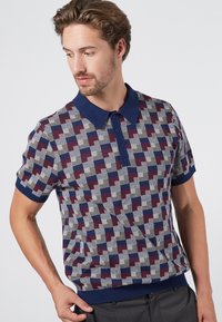 Kurzarm-Poloshirt mit kariertem Muster in Marineblau, Bordeaux und Creme; gerippter Kragen und Saum, geknöpfte Frontleiste.