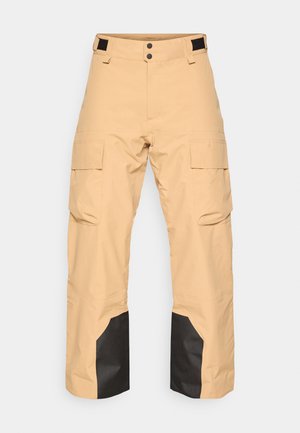 Pantaloni cargo bej cu accente negre pe picioare, prevăzuți cu două buzunare laterale, un talie cu nasturi și o croială lejeră. Fabricat dintr-un material neted.