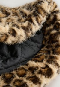 Quilted black fabric interior with a leopard print faux fur trim. Trim features varied brown and cream spots, enhancing texture and visual interest.
