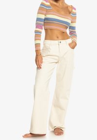 Cremfarbene, weit geschnittene Hosen mit lockerem Sitz und Seitentaschen, kombiniert mit einem mehrfarbigen, gerippten Croptop mit langen Ärmeln.