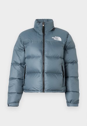 Modrá vypolstrovaná bunda s vysokým golierom, predným zipsom, bočnými zipsovými vreckami, nastaviteľnými manžetami a bielym logom "The North Face" na hrudi.