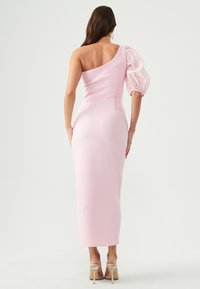 Pink, fitted dress with a single shoulder design. One sleeve is puffed, made of sheer material with polka dots. Smooth texture, ankle length.