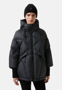 Sort pufferjakke med hætte, med diamantformet syning, lynlås foran og snoretræk. Sammen med en sort ribbet hue.