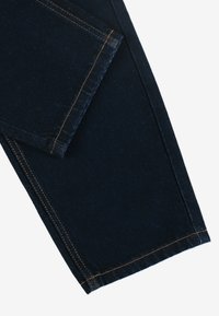 Ciemnoniebieskie dżinsy z pomarańczowym przeszyciem; mają prostą nogawkę, standardowe kieszenie i gładką fakturę.