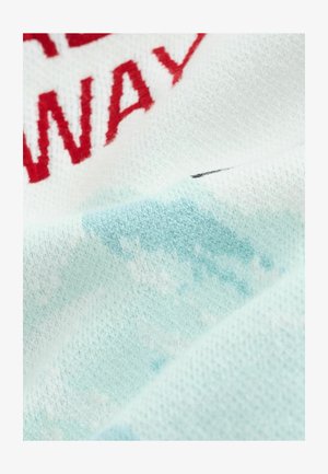 Dzianina w jasnoniebieskim kolorze z białymi akcentami; posiada czerwony haftowany tekst oraz miękką, teksturowaną powierzchnię z delikatnym wzorem gradientowym.