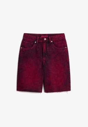 Red denim shorts with a distressed finish, five pockets, metal button closure, and frayed hem. The fabric has a textured appearance.