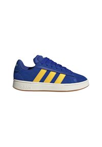 Baskets Adidas basses bleues avec trois bandes jaunes, semelle blanche et lacets bleus, vues de côté sur un fond blanc.