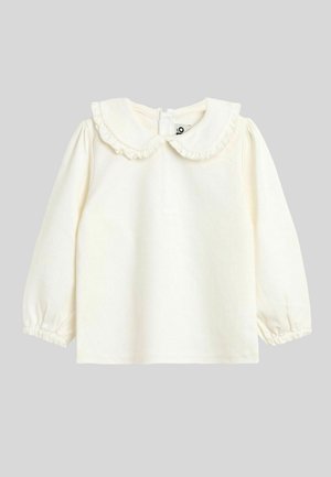 Top a maniche lunghe color crema con colletto arricciato e chiusura a bottoni sul retro. Tessuto morbido con polsini arricciati e texture liscia.