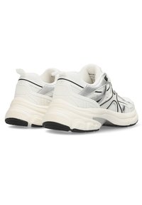 Bílé a stříbrné sportovní boty s síťovinou, černými akcenty, silným polstrováním a texturovanou podrážkou. Obsahují poutko na patě.