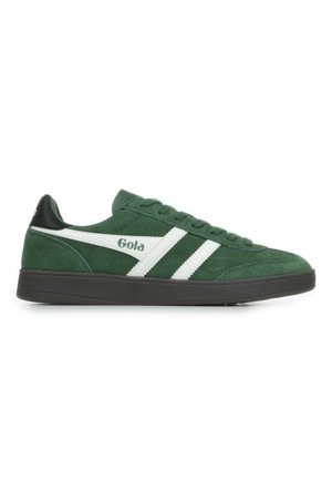 Sneaker in suede verde con strisce bianche e branding. Presenta un accento nero sul tallone e una suola in gomma piatta. Design con lacci.