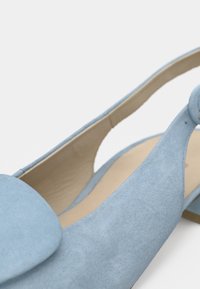 Γαλάζιο σουέτ παπούτσι slingback με στρογγυλεμένη μύτη, διακοσμημένο με ομαλή υφή και απαλό, φαρδύ λουράκι με λεπτομέρεια κουμπιού.