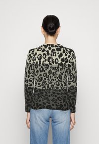 Maglione lavorato a maglia con stampa leopardata in diverse tonalità di verde e nero, caratterizzato da un collo tondo, maniche lunghe e una vestibilità leggermente ampia.