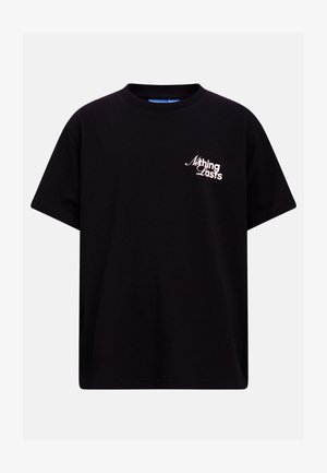 Čierne tričko s krátkym rukávom a bielym textom "Nothing Lasts" na ľavej strane hrude, zobrazené na jednoduchom svetlosivom pozadí.