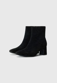 Black suede ankle boots with a pointed toe and block heel. Features smooth texture and stitched detailing on the body and seams.