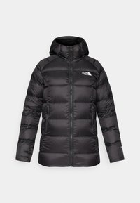 Casaco puffer preto com capuz, apresentando fecho zip, secções largas acolchoadas e um pequeno logótipo branco no lado esquerdo do peito. Textura suave.