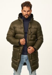 Olivengrüne Puffjacke mit Kapuze, Reißverschluss und mehreren Fronttaschen; gestepptes Design mit langer Silhouette.
