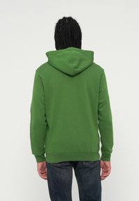 Sweatshirt verde com capuz, de textura suave, com punhos e cintura canelados, apresentando um design simples da vista traseira.