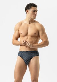 Donkerblauwe zwemboxers met een geometrisch patroon, gemaakt van rekbaar materiaal, bieden een strakke pasvorm en hebben een gemerkte tailleband.