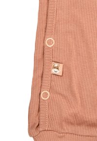 Ribbed terracotta fabric featuring a small animal patch and two round buttons on the side for closure. Soft texture and snug fit.
