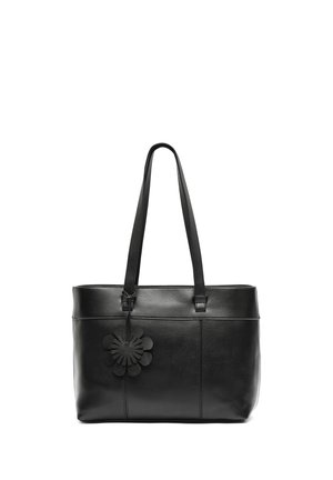 Black leather tote bag with long straps and a black flower-shaped charm hanging near the top left corner.