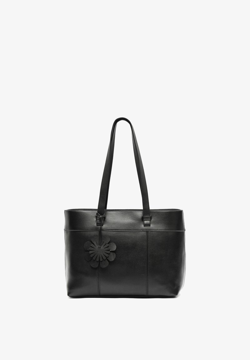Czarna skórzana torba tote z długimi paskami i czarnym, kwiatowym breloczkiem zawieszonym w górnym lewym rogu.