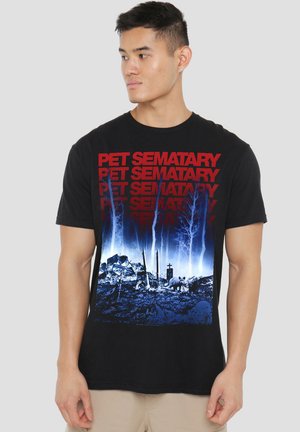 Schwarzes Baumwoll-T-Shirt mit einem blauen und roten Grafikdruck von "Pet Sematary", der eine Friedhofsszene, Bäume und Silhouetten zeigt.