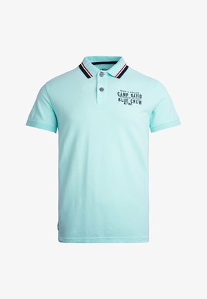 Jasnoniebieska koszulka polo z kołnierzykhem, ozdobiona czerwonymi i granatowymi paskami, z dwoma guzikami oraz nadrukiem z przodu przedstawiającym tekst i szczegóły logo.