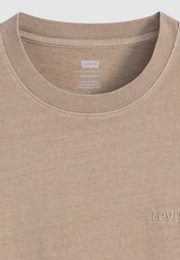 Beige Levi's vintage fit bomulls-t-skjorte med ribbestrikket rund hals og diskret Levi's-logo brodert på brystet.