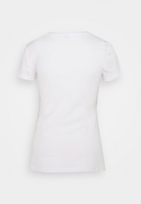 Camiseta blanca de manga corta con escote redondo, hecha de suave tejido de algodón, con un respaldo sin costuras y una forma ajustada.