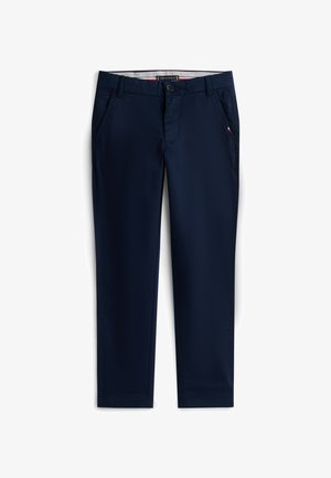 Tamsiai mėlynos, lieknos kelnės su priekinėmis kišenėmis, sagos užsegimu, diržo kilpomis ir subtiliu vėliavos detalumu dešinėje kišenėje.