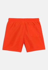 Φωτεινά πορτοκαλί μαγιό σορτς με ελαστική μέση και μια τσέπη στο πίσω μέρος δεξιά, παρουσιάζονται επίπεδα σε λευκό φόντο.