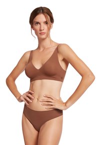 Set di reggiseno e panty seamless marrone con una texture liscia. Il reggiseno presenta spalline larghe e un design a V, mentre il bikini ha un taglio a vita bassa.
