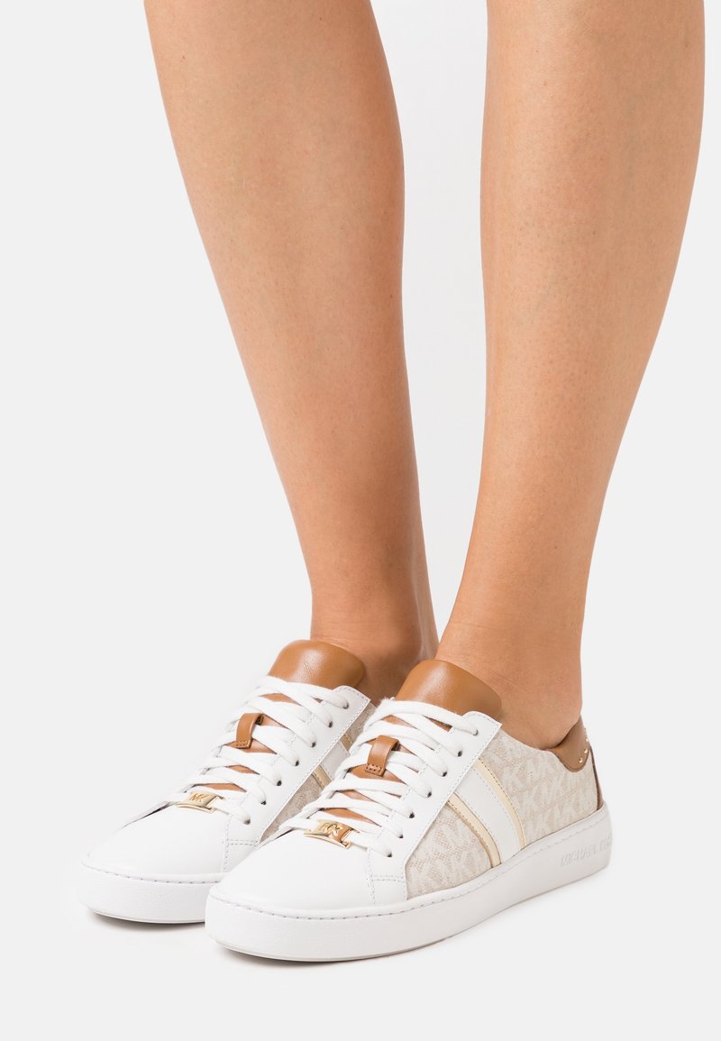 Sneakers bianchi con accenti in pelle, dotati di un pannello laterale in tessuto a motivi, punta tonda e suola piatta in gomma. Lacci marroni e dettaglio sul tab.