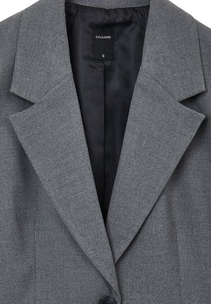 Grauer Blazer mit strukturierter Oberfläche, Reverskragen und einem einzelnen schwarzen Knopfverschluss. Mit glatter schwarzer Innenauskleidung. Größe S.