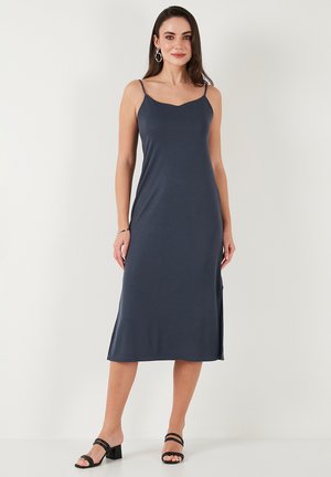 Sleeveless, navy dress made of soft fabric, featuring a knee-length cut and side slits for ease of movement. Simple, elegant design.