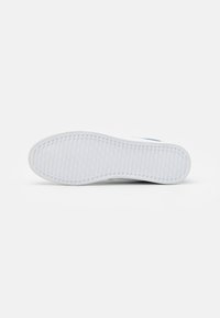 Witte sneaker-zool met een textuurpatroon voor grip, voorzien van een gladde randdesign. Geen zichtbare logo's of contrasterende kleuren.