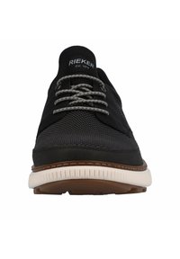Black sneaker with mesh upper, gray laces, rubber sole, and light brown accents. Features branding on the tongue and textured surface.