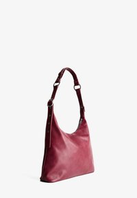 Burgundy bőr válltáska sima textúrával, széles pánttal és ezüstszínű fémszerelvényekkel, lazán eső, aszimmetrikus formával.
