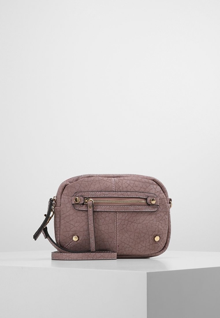 Ryppyinen violetti nahkainen olkalaukku, jossa on vetoketjutasku edessä, kullanväriset metalliosat ja irrotettava hihna. Neliön muotoinen.