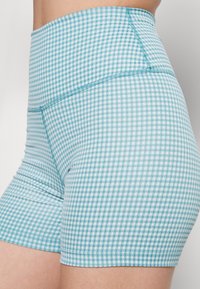 Szorty wysokiej talii w niebieski wzór w kratkę. Elastyczna talia i gładki materiał zapewniający komfort. Szczegóły szycia wzdłuż szwów.