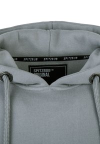 Felpa grigia con cappuccio e cordino, caratterizzata da una texture morbida. Il colletto interno ha un'etichetta nera con la scritta "SPITZBUB ORIGINAL" in caratteri bianchi.