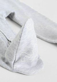 Gray cotton item with a triangular accent, featuring a textured surface and faint white patterns. The design includes rounded edges.