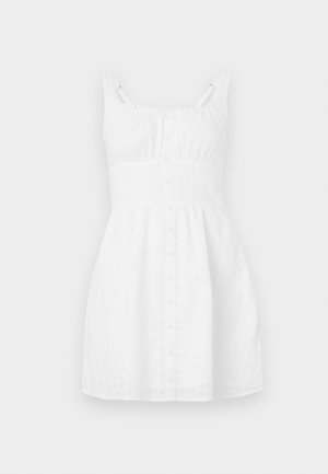 White cotton dress with a grid pattern, sleeveless design, button-down front, gathered waistline, and subtle lace accents on straps.