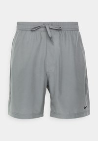 Short de sport gris avec taille élastique, cordon, poches latérales et petit logo Nike noir sur l'ourlet gauche.