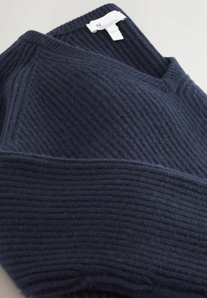 Navy blue ribbed knit sweater with V-neck and visible white clothing label on a light background.