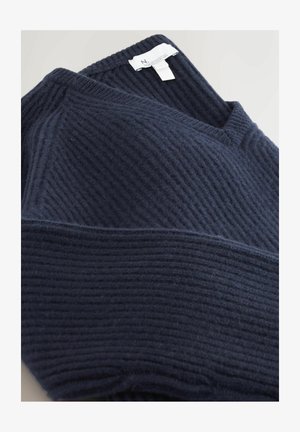Navy blue ribbed knit sweater with V-neck and visible white clothing label on a light background.