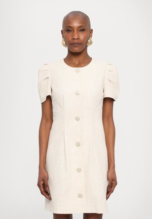 Beige linnen jurk met pofkorte mouwen en een rechte snit, met vijf decoratieve knopen aan de voorkant en subtiele verticale naden.