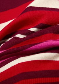 Strickstoff mit kräftigen horizontalen Streifen in verschiedenen Rottönen, Rosa und Creme, mit weicher Textur und leicht elastischer Qualität.