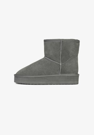 Bottines en suede grises avec un bout arrondi, une semelle plate, des détails en surpiqûres et une doublure intérieure douce. Design simple sans embellissements.