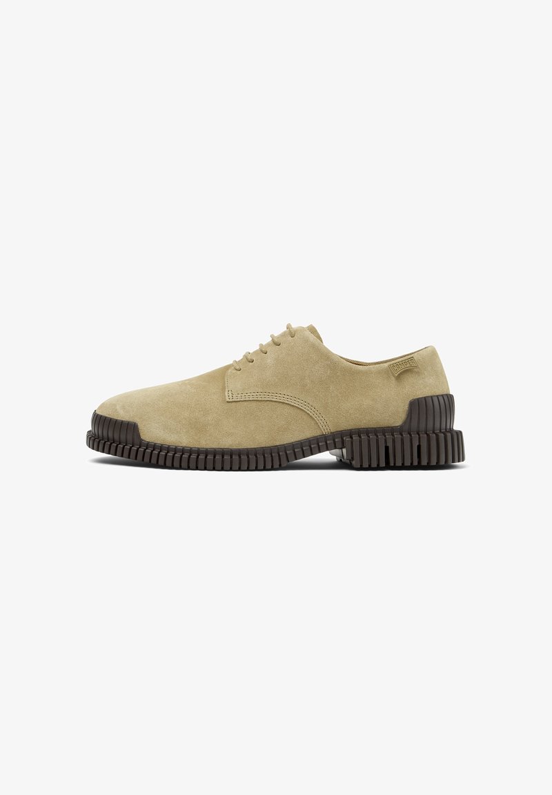 Chaussure beige en daim à lacets avec une semelle noire épaisse et texturée et un petit talon, vue de côté, logo Camper sur la languette du talon.
